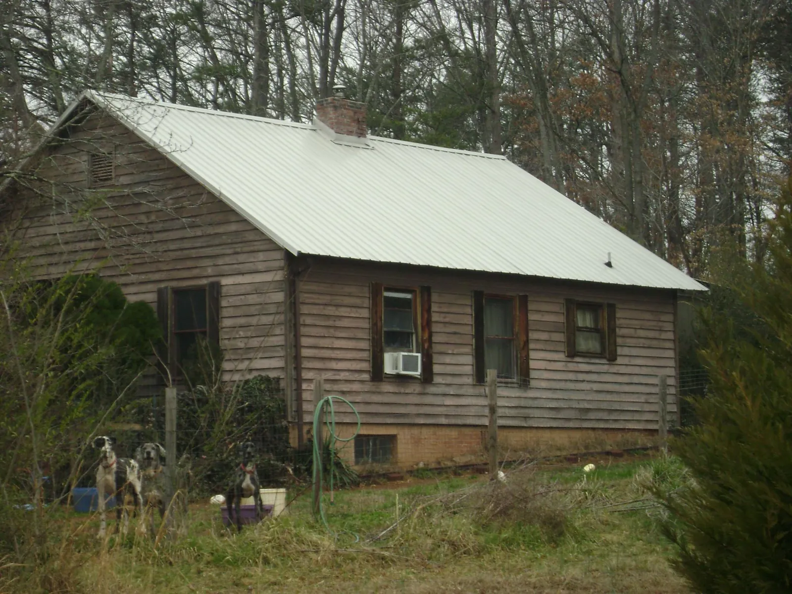 White metal roof on an old wood sided farmhouse, from a Metal Roof Installation job in Manvel